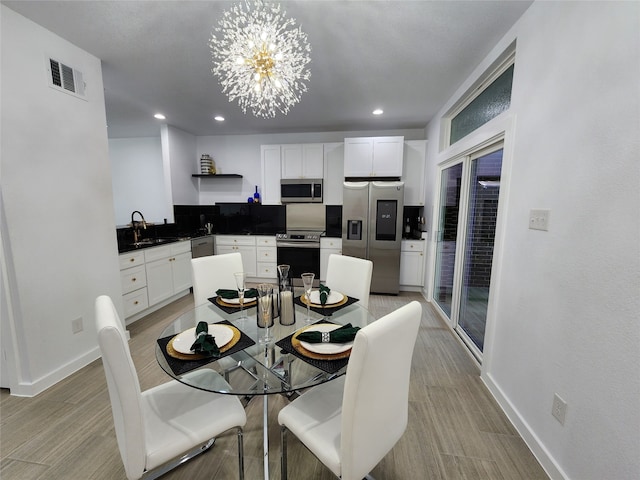 dining space with sink and an inviting chandelier