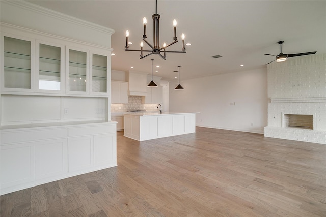 unfurnished living room featuring a fireplace, crown molding, and light hardwood / wood-style floors