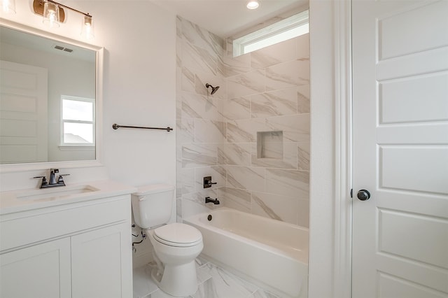 full bathroom with tiled shower / bath combo, vanity, and toilet