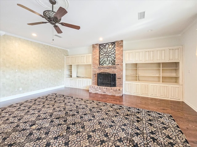 unfurnished living room featuring a brick fireplace, ornamental molding, dark hardwood / wood-style flooring, and ceiling fan