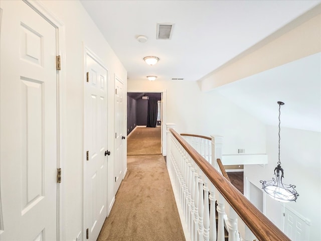 hall with light carpet and vaulted ceiling