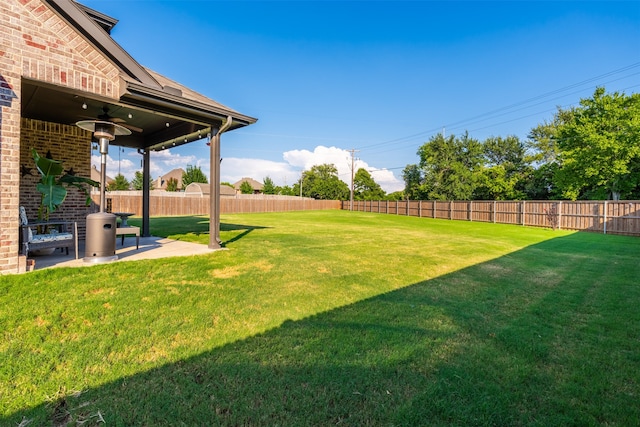 view of yard featuring ceiling fan and a patio