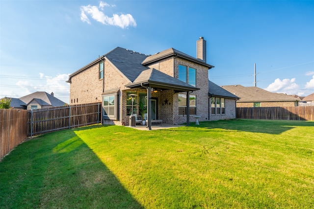 rear view of house with a patio area and a lawn