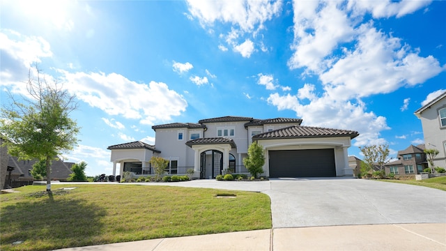 mediterranean / spanish home featuring a front yard and a garage