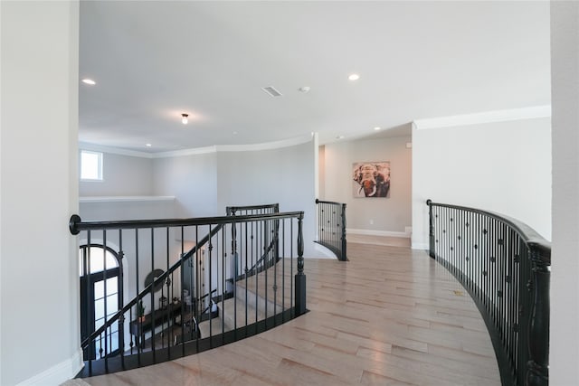 hall with light hardwood / wood-style flooring and ornamental molding