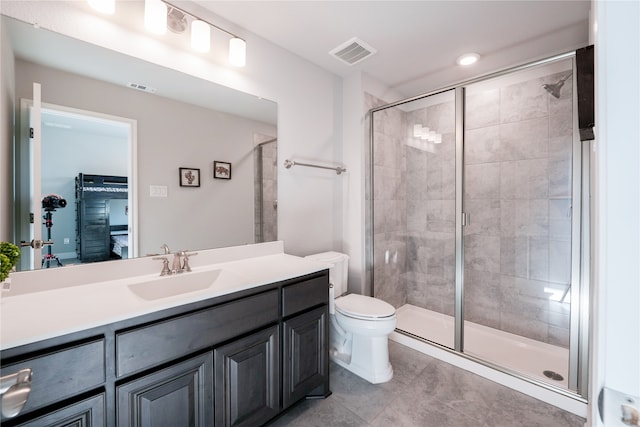 bathroom featuring vanity, a shower with shower door, and toilet