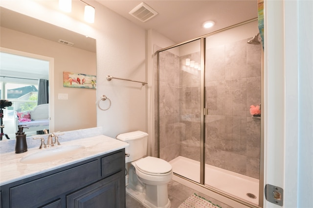 bathroom featuring tile patterned flooring, toilet, a shower with door, and vanity