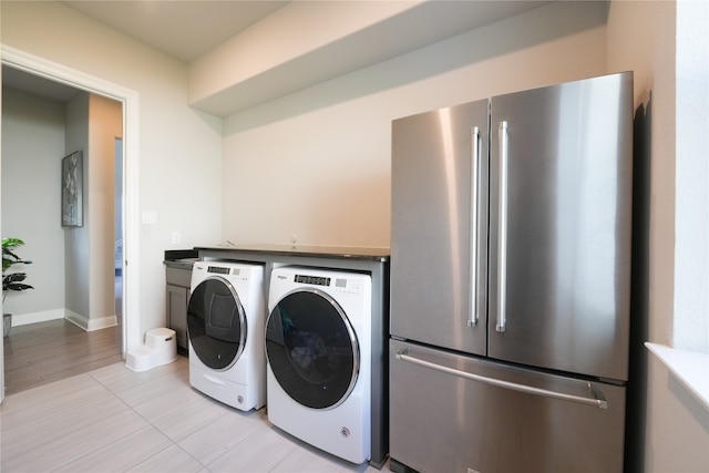 laundry room with washing machine and dryer and light hardwood / wood-style flooring