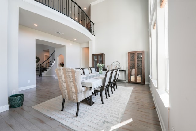 dining area featuring light hardwood / wood-style floors and a high ceiling