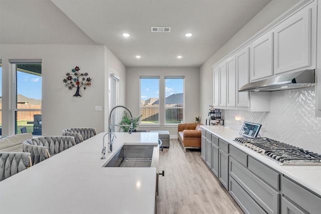 kitchen with open floor plan, light countertops, and under cabinet range hood