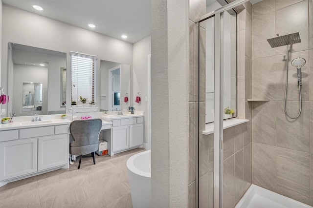 full bathroom featuring a stall shower, a freestanding tub, two vanities, and a sink