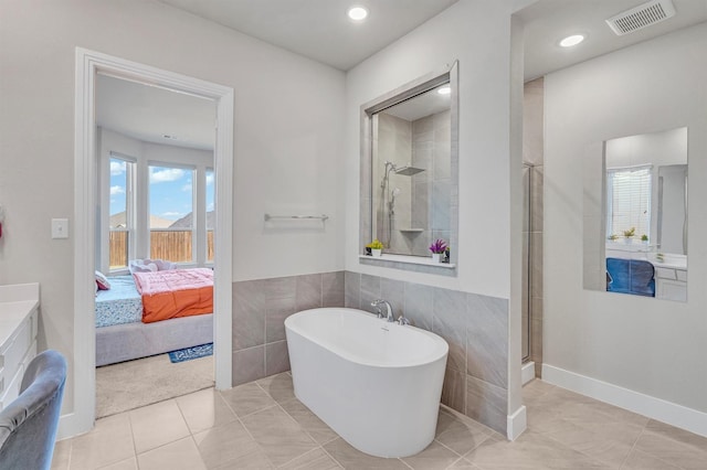 2104 Devonblue Dr, Forney, TX 75126 - bathroom featuring a freestanding bath, tile walls, connected bathroom, a shower, and vanity