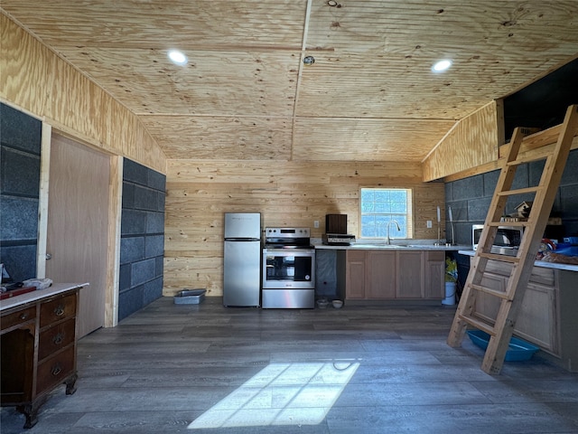 kitchen featuring appliances with stainless steel finishes, dark hardwood / wood-style flooring, light brown cabinetry, wooden walls, and sink