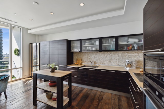 kitchen with sink, backsplash, plenty of natural light, floor to ceiling windows, and oven