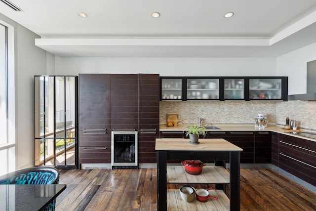 kitchen with tasteful backsplash, wine cooler, dark brown cabinetry, and dark hardwood / wood-style flooring