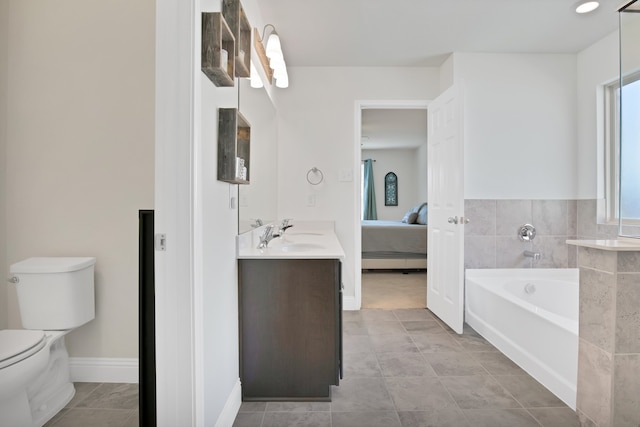 bathroom with tile patterned flooring, vanity, toilet, and a tub to relax in