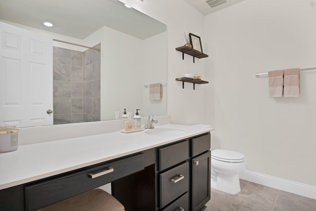 bathroom featuring tile patterned flooring, vanity, tiled shower, and toilet