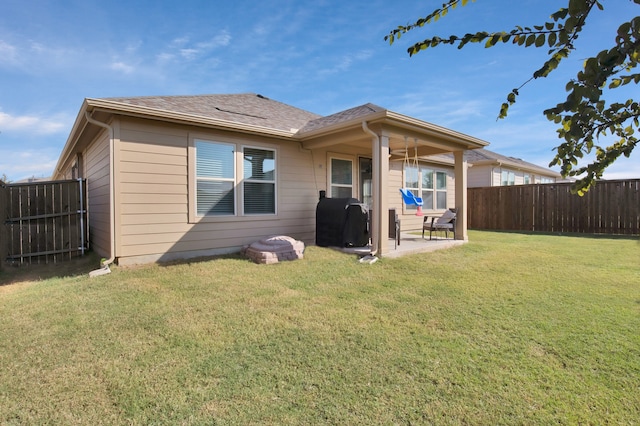 rear view of property with a lawn and a patio