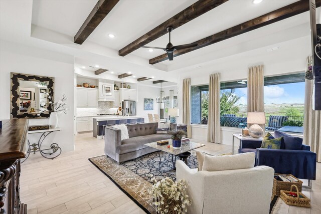 living room with light wood-type flooring, beamed ceiling, and ceiling fan