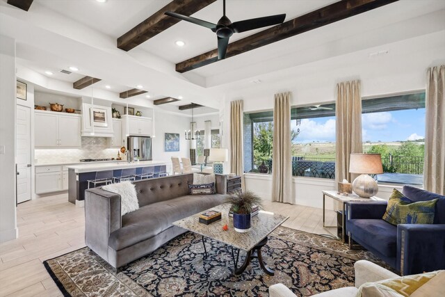 living room with beamed ceiling, light wood-type flooring, and ceiling fan