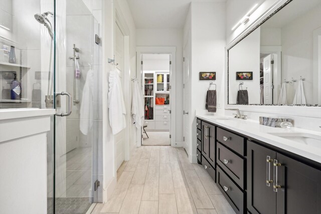 bathroom with a shower with door and vanity