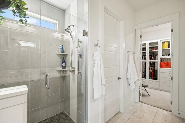 bathroom featuring tile patterned flooring and a shower with shower door