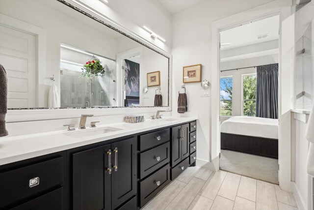 bathroom with a shower with door and vanity