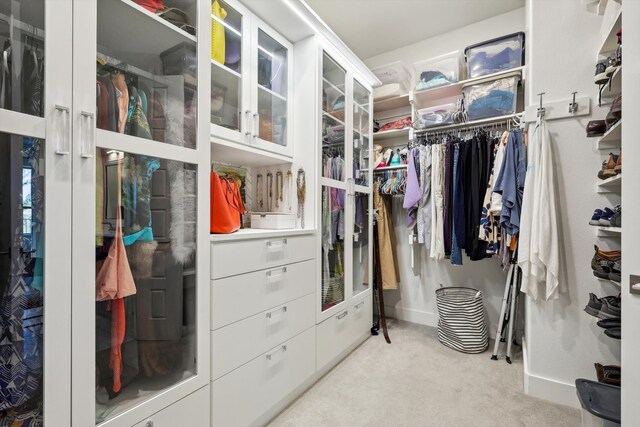 walk in closet featuring light colored carpet