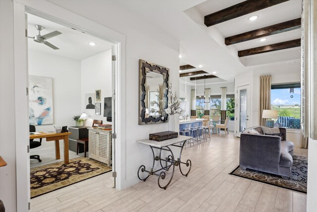 hall with light hardwood / wood-style flooring and beam ceiling