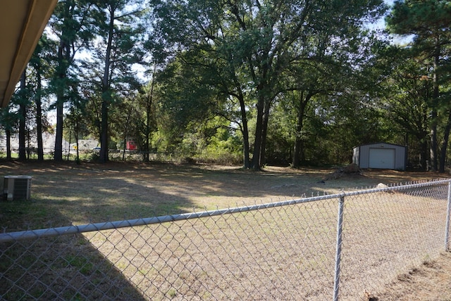 view of yard featuring central AC, a garage, and an outdoor structure