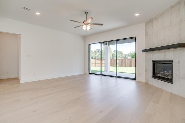 unfurnished living room featuring a fireplace, ceiling fan, and light hardwood / wood-style floors