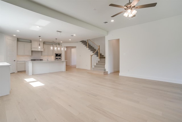 unfurnished living room featuring light wood-type flooring and ceiling fan