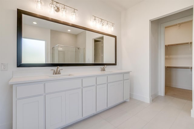 bathroom featuring a shower with door and vanity