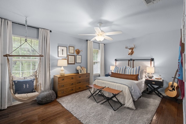 bedroom with multiple windows, ceiling fan, and dark wood-type flooring