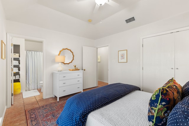 tiled bedroom featuring ceiling fan and a closet