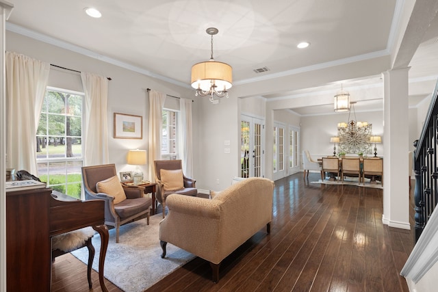 living room featuring ornamental molding, french doors, decorative columns, a notable chandelier, and dark hardwood / wood-style flooring