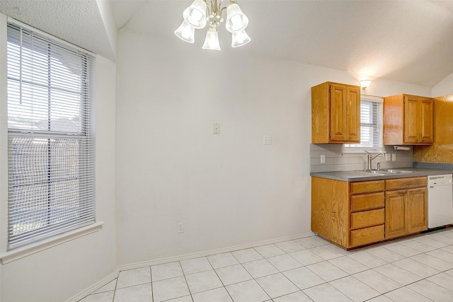 kitchen featuring lofted ceiling, sink, light tile patterned floors, and dishwasher