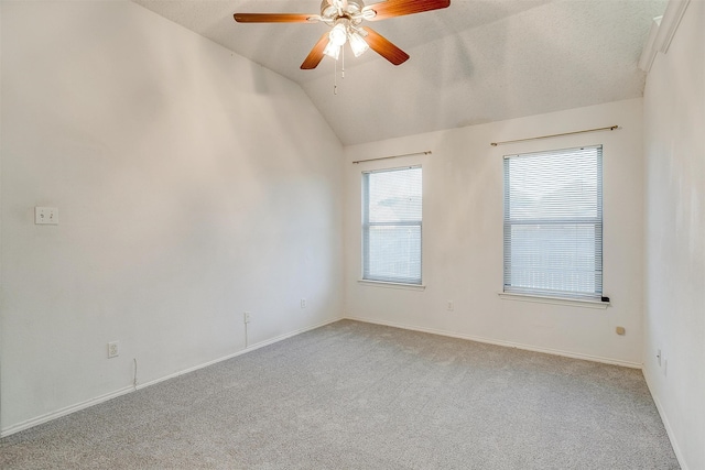 empty room with lofted ceiling, a textured ceiling, light colored carpet, and ceiling fan