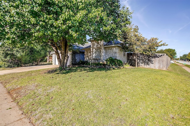 obstructed view of property with a garage and a front lawn