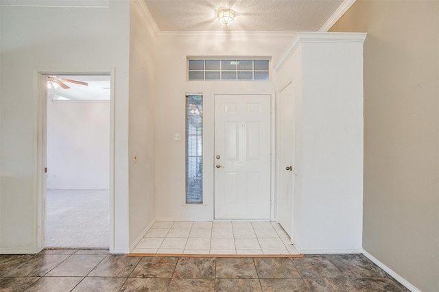 entryway with ceiling fan, a textured ceiling, crown molding, and carpet