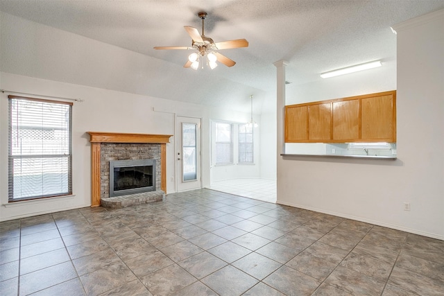 unfurnished living room featuring a fireplace, a wealth of natural light, ceiling fan, and lofted ceiling