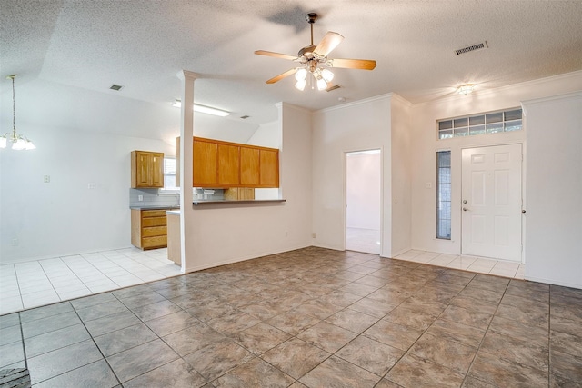 unfurnished living room featuring ornamental molding, a textured ceiling, ceiling fan, and light tile patterned flooring