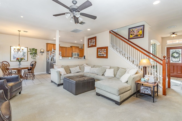 living room featuring ceiling fan with notable chandelier and light carpet