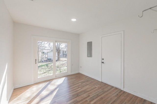 unfurnished room featuring electric panel and light hardwood / wood-style floors