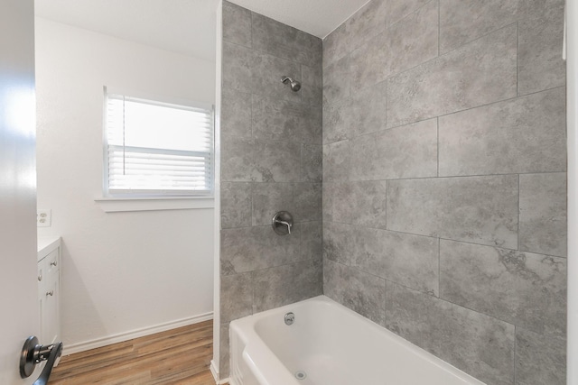 bathroom with vanity, tiled shower / bath combo, and hardwood / wood-style floors