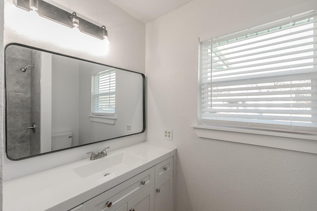 bathroom featuring vanity, toilet, and walk in shower