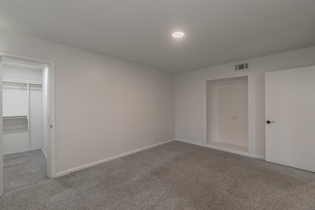 unfurnished bedroom featuring a walk in closet, carpet floors, and a closet