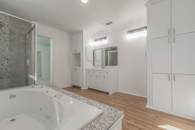 bathroom featuring hardwood / wood-style flooring, vanity, ornamental molding, and plus walk in shower