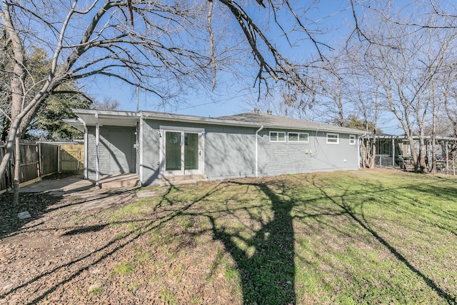 rear view of house featuring a lawn