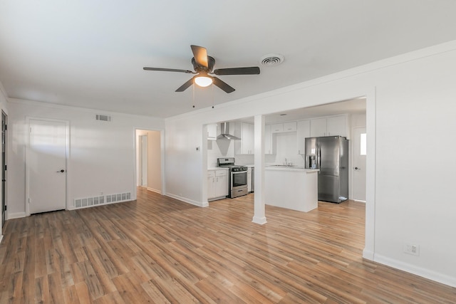 unfurnished living room with ceiling fan, sink, and light wood-type flooring